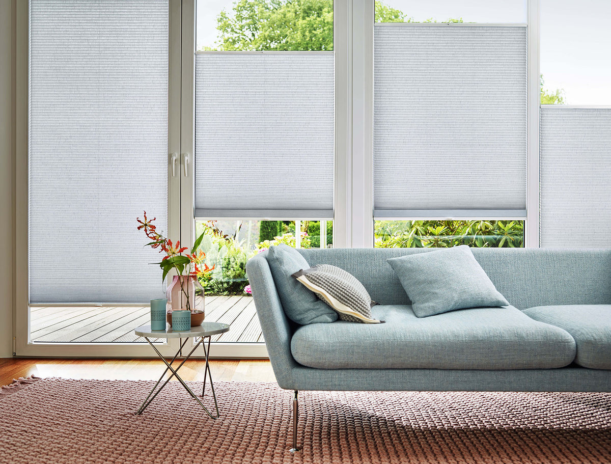 Wohnzimmer mit Plissees als textilem Sichtschutz am Fenster