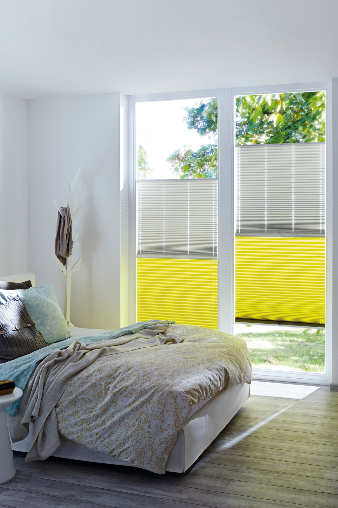 Wohnraum mit grauem und gelbem Plissee am Fenster